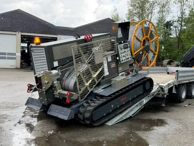 Crawler-mounted winch with cable drum and pulling rope